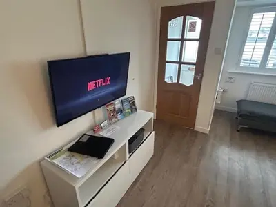 a living room with a flat screen tv on a wall at Beach Stroll Retreat, Swanage, Dorset in Moffat