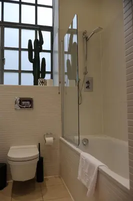 a bathroom with a tub and a toilet and a shower at Stockbridge 1BR with Parking in Edinburgh