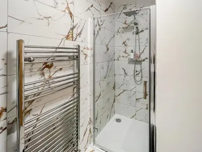 a bathroom with a shower with a mirror at Eriska View in Port Appin