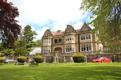 an old house with a red car parked in front of it at Inglewood House and Spa in Alloa