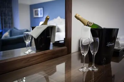 a bottle of champagne and two wine glasses on a counter at Inglewood House and Spa in Alloa