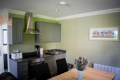 a kitchen with a wooden table and a counter top at Inglewood House and Spa in Alloa