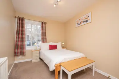 a small bedroom with a bed and a window at Bow Apartment in Stirling