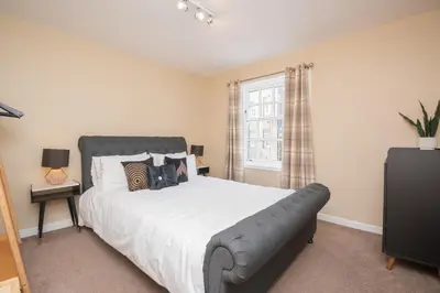 a bedroom with a large bed and a window at Bow Apartment in Stirling