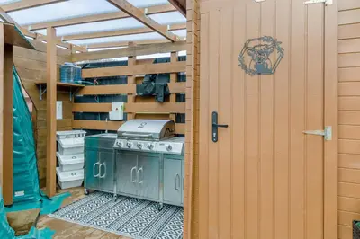 a backyard kitchen with a stove and a wooden wall at 1 Bed in Denny oc-h33665 in Denny