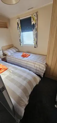 two beds in a small room with a window at Terri Towers in Stevenston