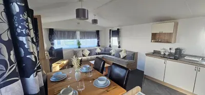 a kitchen and a living room with a table and a couch at Terri Towers in Stevenston