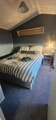 a bedroom with a bed with a striped comforter at Terri Towers in Stevenston