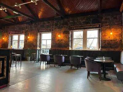 a restaurant with tables and chairs in a room at Paisley Central Apartment in Paisley