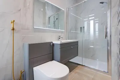 a white bathroom with a toilet and a shower at Savoy 5 in Ayr