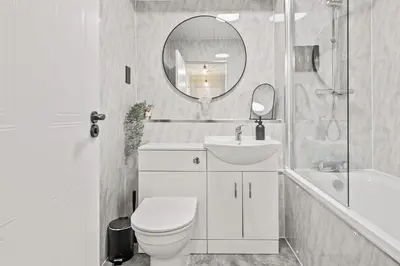 a bathroom with a toilet and a sink and a mirror at The Riverside Rest 2 in Stirling
