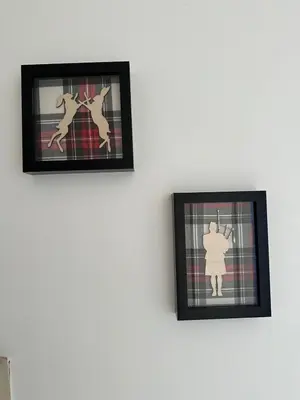 two framed pictures of people on a wall at Lochside Hub in Balloch