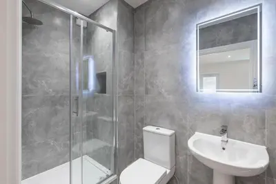 a bathroom with a shower and a toilet and a sink at Stone Street Modern 3-Bed for Groups & Families in Broughton
