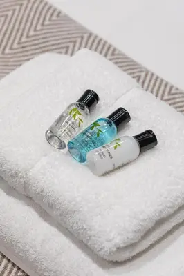 two bottles of liquids sitting on top of a towel at Stone Street Modern 3-Bed for Groups & Families in Broughton