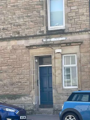 a building with a blue door and a car parked in front at Room with a view in Irvine