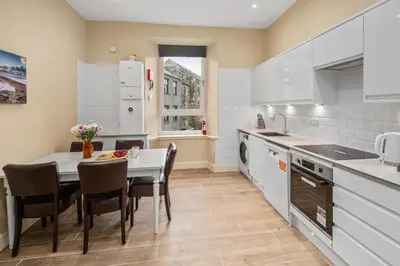 a kitchen with a table and chairs in a kitchen at The Oban Apartment in Oban