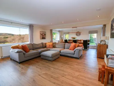 a large living room with a couch and a table at Cramar Cottage in Glasgow
