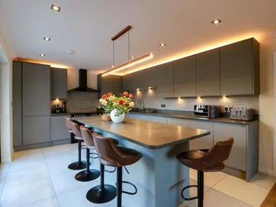a kitchen with a large island with bar stools at Cramar Cottage in Glasgow