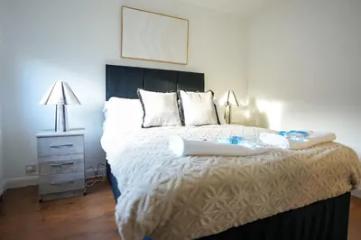 a bedroom with a bed and a night stand at Nigel House in Livingston