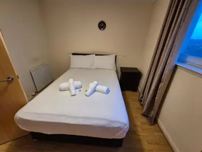 a bedroom with a bed with two rolls of paper on it at Glasgow Southside Apartment in Glasgow