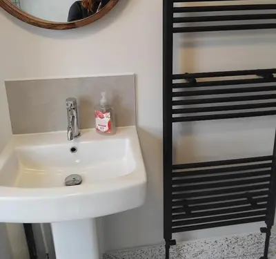 a bathroom with a sink and a mirror and a shelf at A room in a house in Moffat