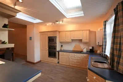a kitchen with wooden cabinets and a skylight at Mariners Haven in Troon in Troon