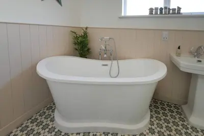 a white bath tub in a bathroom with a sink at Mariners Haven in Troon in Troon