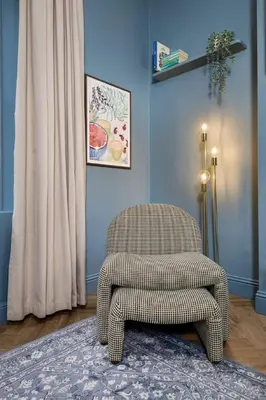 a chair sitting in a living room next to a curtain at Modern 1-Bed Retreat by Stirling Train Station in Stirling