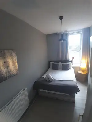 a small bedroom with a bed with a window at Cosy Apartment by the Meadows 2 in Edinburgh