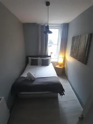 a small bedroom with a bed with a window at Cosy Apartment by the Meadows 2 in Edinburgh
