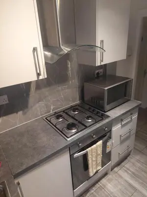 a kitchen with a stove and a microwave at London Cozy Single Room in Moffat