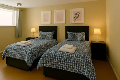 two beds sitting next to each other in a bedroom at Carvetii - Jute House, ground floor, 2 bedroom flat in Rosyth