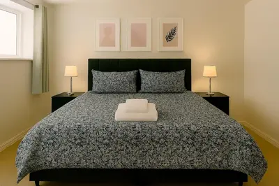 a bedroom with a large bed and two lamps at Carvetii - Jute House, ground floor, 2 bedroom flat in Rosyth