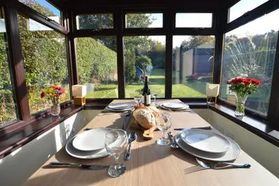 a table with plates and glasses on a table with windows at An Cala in Connel