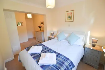 a bedroom with a white bed with towels on it at An Cala in Connel