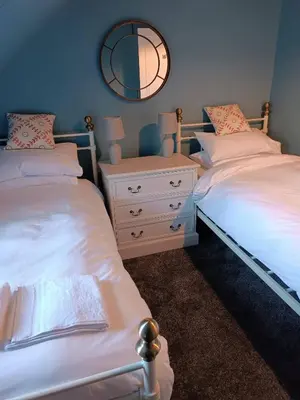 a bedroom with two beds and a mirror on the wall at Island View in Campbeltown
