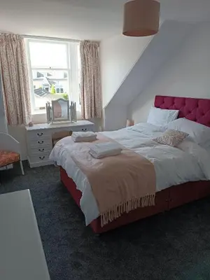 a bedroom with a large bed and a window at Island View in Campbeltown