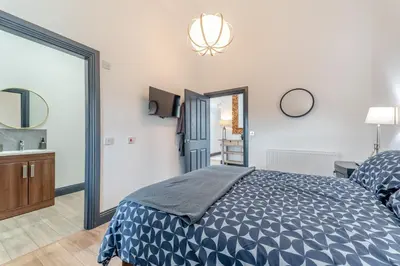 a bedroom with a large bed and a mirror at 5 Bed in Galston oc-s33451 in Galston