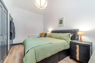 a bedroom with a bed with a green comforter at 5 Bed in Galston oc-s33451 in Galston