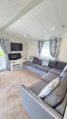a living room with couches and a flat screen tv at Caravan Bliss in Minishant