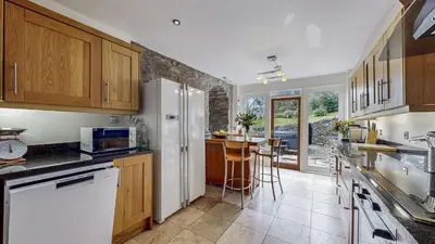a kitchen with wooden cabinets and a white refrigerator at Finest Retreats - Old Barn at Ormidale House in Clachan of Glendaruel