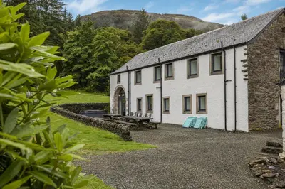 a white building with a picnic table in front of it at Finest Retreats - Old Barn at Ormidale House in Clachan of Glendaruel