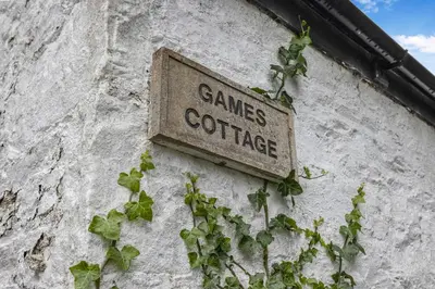 a sign on the side of a building with plants at Finest Retreats - Garden Cottage at Ormidale House in Clachan of Glendaruel
