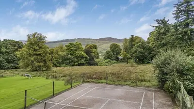 an image of a tennis court in a field at Finest Retreats - Garden Cottage at Ormidale House in Clachan of Glendaruel
