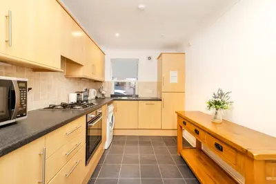 a kitchen with wooden cabinets and a microwave at JOIVY Lovely Flats in Edinburgh City Centre in Edinburgh