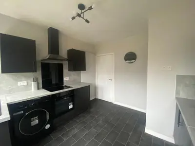 a kitchen with a black counter and a stove at 3BR Sleeps 6 Free Parking Near Glasgow City Centre in Renfrew