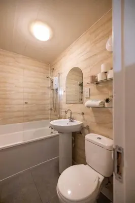 a bathroom with a toilet and a sink and a tub at 53 Dorset street G3 7AG in Glasgow