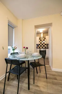 a dining room with a table and chairs and a kitchen at 53 Dorset street G3 7AG in Glasgow
