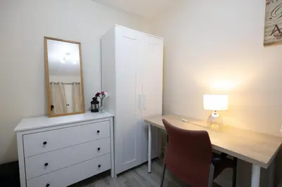 a bedroom with a dresser and a desk with a mirror at 53 Dorset street G3 7AG in Glasgow