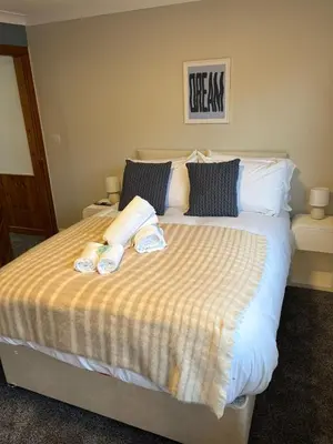 a bedroom with a bed with two towels on it at Vacant Nests Ivy Cottage 3BR Wi-Fi in Kilsyth